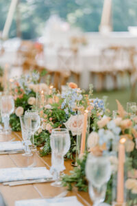 Long reception table styled with pastel florals, candlelight, and layered textures at one of the more elevated wedding venues in Newport RI.