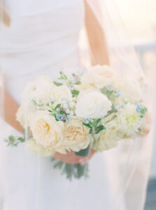 Soft-focus close-up of a bridal bouquet filled with cream roses and delicate greenery photographed during an elegant Newport Rhode Island wedding.