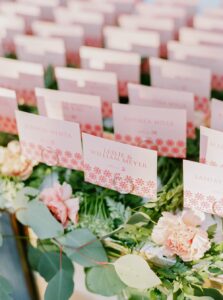 Brooklyn Botanic Garden Wedding | Deirdre Photography Timeless and Organic Moments | Wedding place cards on greenery hold names and table numbers in elegant pink and white designs.