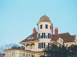 The historic inn rises against a clear blue sky, with its round tower and coastal architecture setting the tone for a classic New England wedding in Newport.